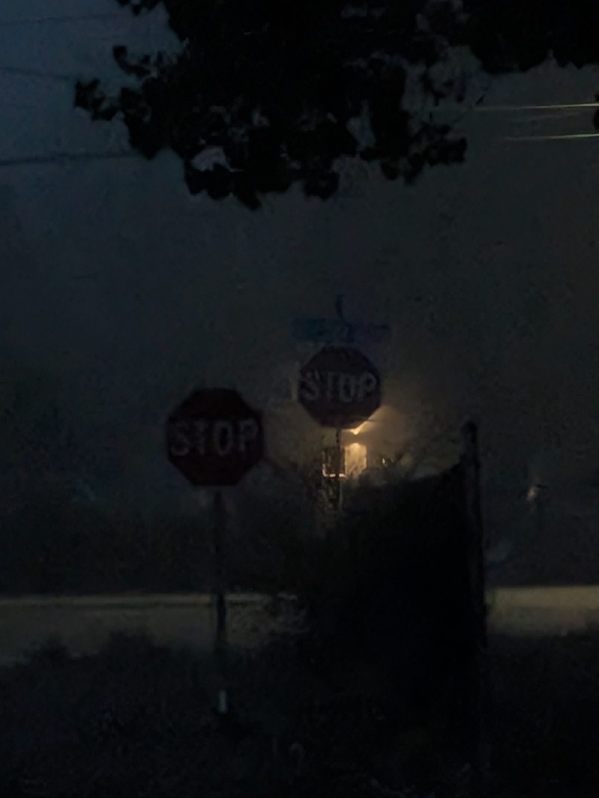 APEX I Alpha Unit STOP sign unlit in heavy fog from about 100 ft, with a standard STOP sign behind it