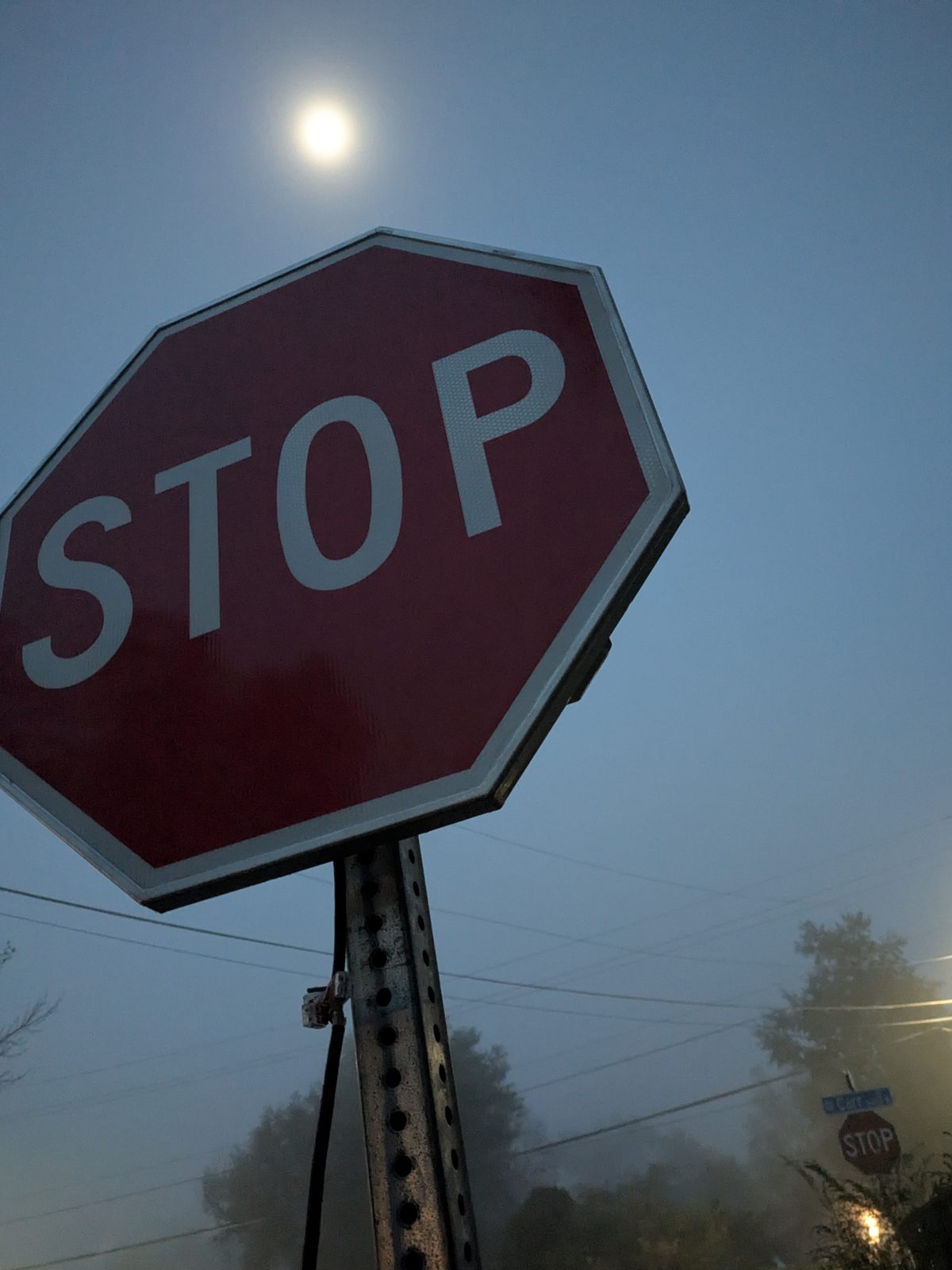 APEX I Alpha Unit STOP sign unlit, seen from below with a streetlight in fog