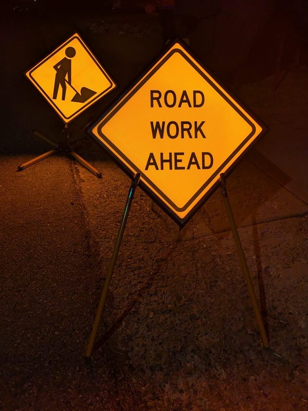 APEX I Alpha Units: W21-1 worker sign and W20-1 ROAD WORK AHEAD sign, lit at night